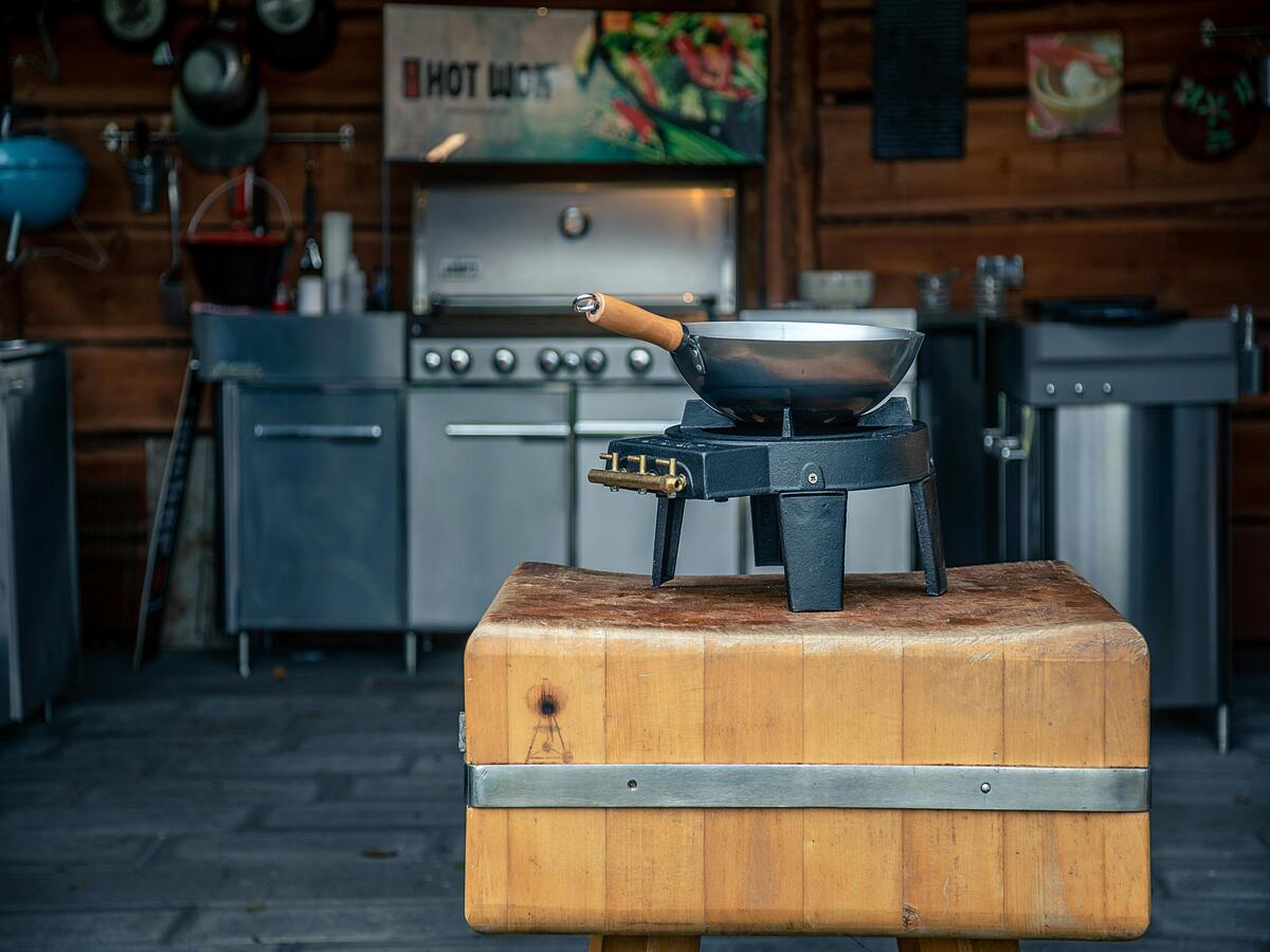 A person learning how to season a wok.